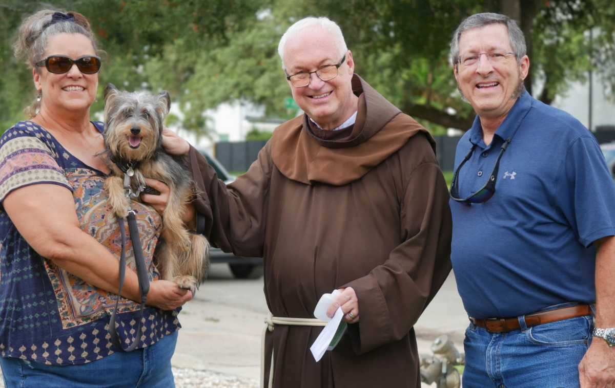 Br. Stephen Kluge, OFM, shares a blessing with a terrier. (Photo courtesy of Sacred Heart Parish)