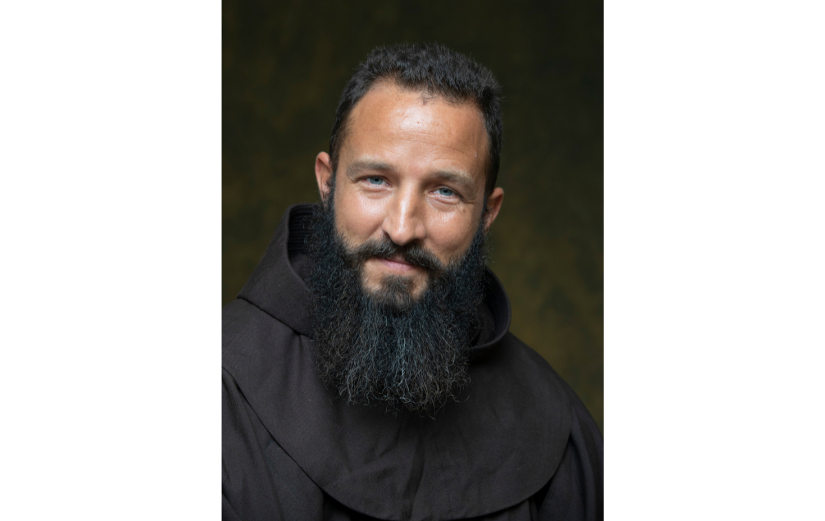 A smiling, bearded man wearing a friar habit.