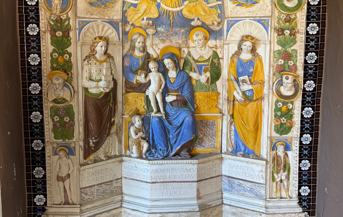 Statues of Mary and the Christ child surrounded by colorful statues of Saints Barbara and Catherine
