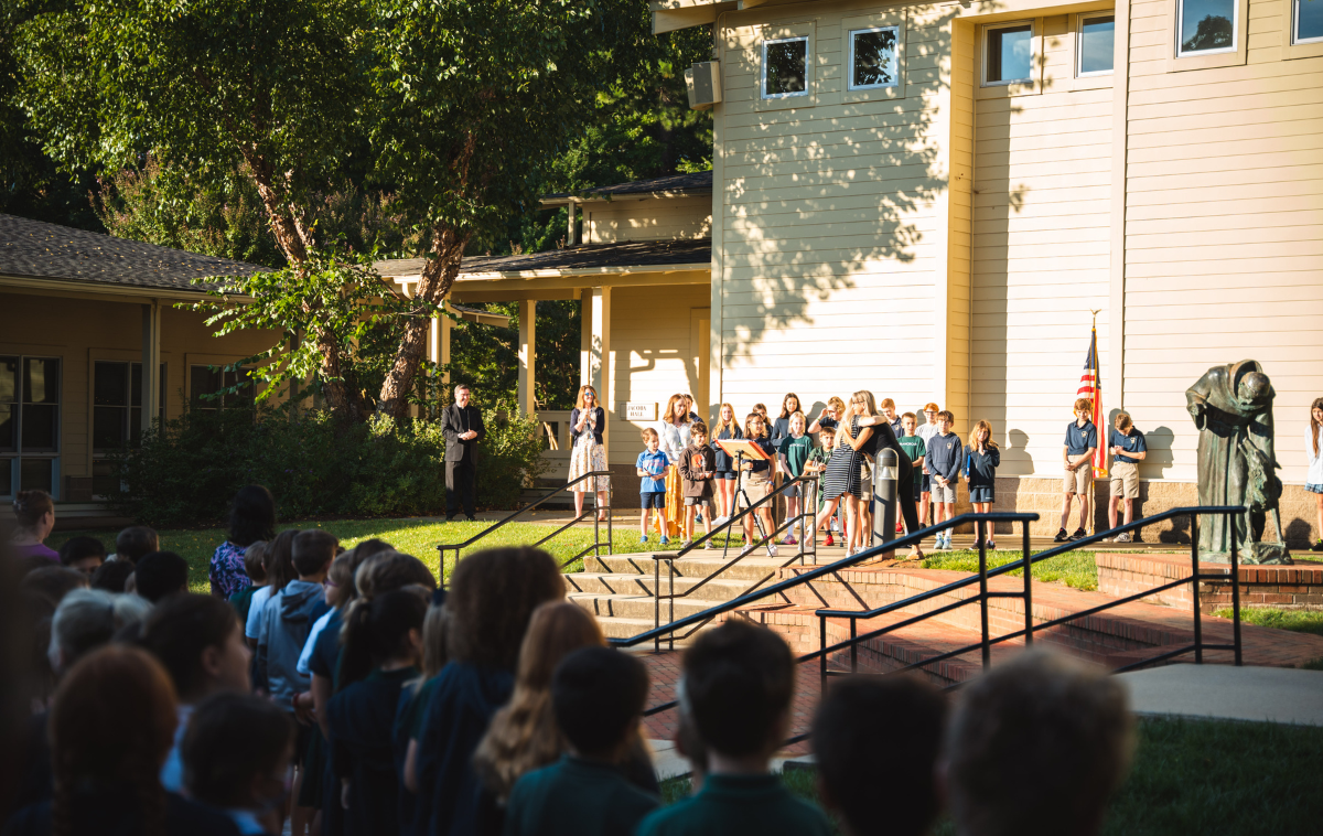 Students gather in the a school courtyard to listen to morning announcements