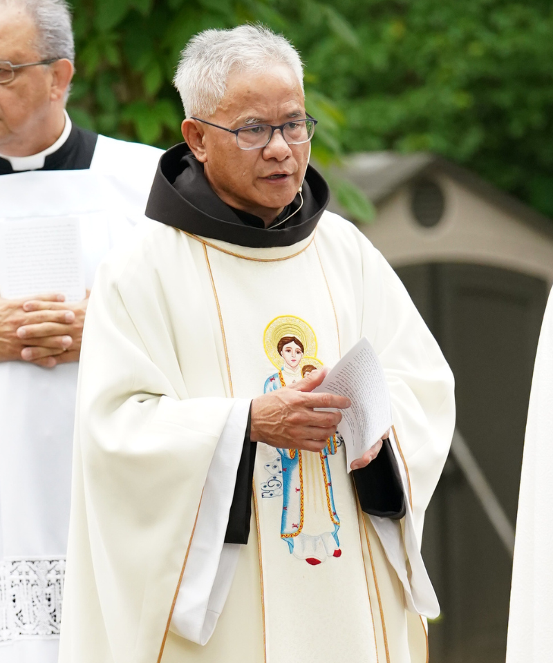 Br. David Phan wears a cream-colored vestment over his brown habit. The vestment is decorated with a beautifully embroidered image of Our Lady of La Vang holding the infant Jesus.