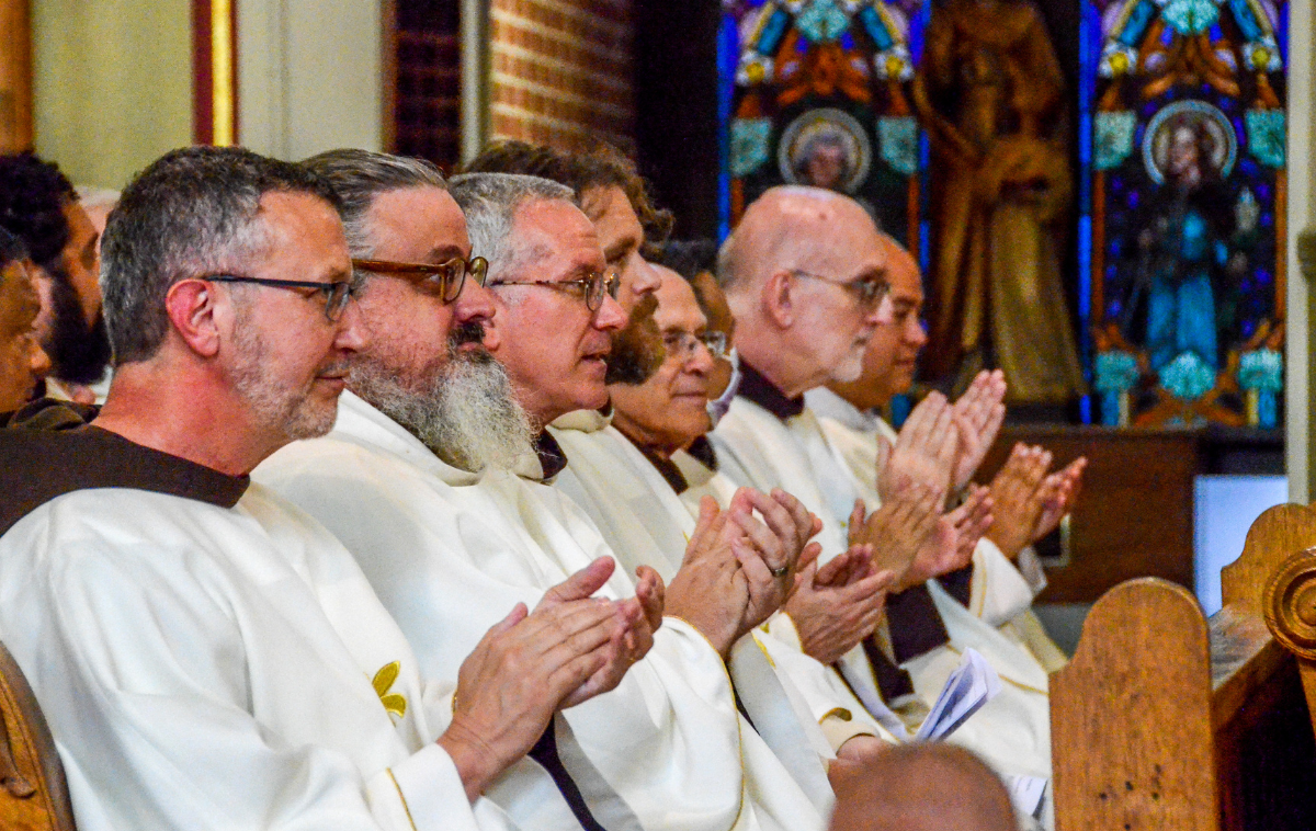 Friar priests clap for Br. John.