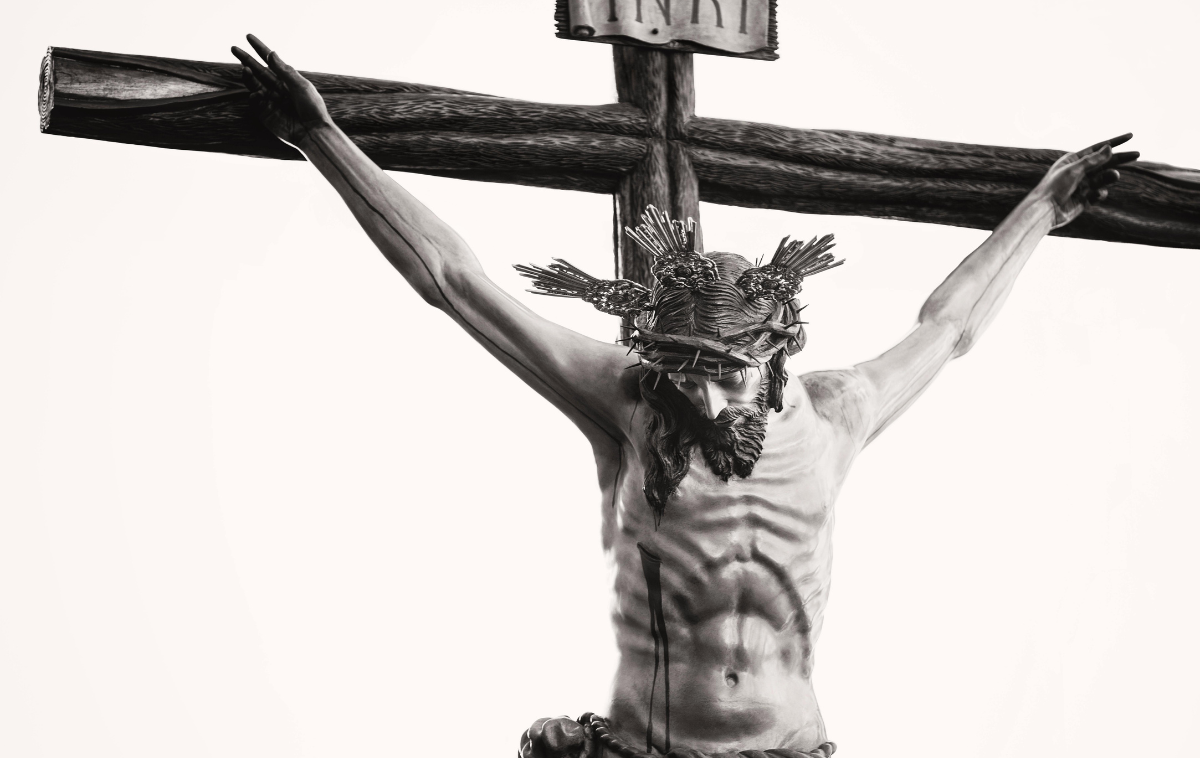 A black and white photo of a statue of Jesus on the cross.