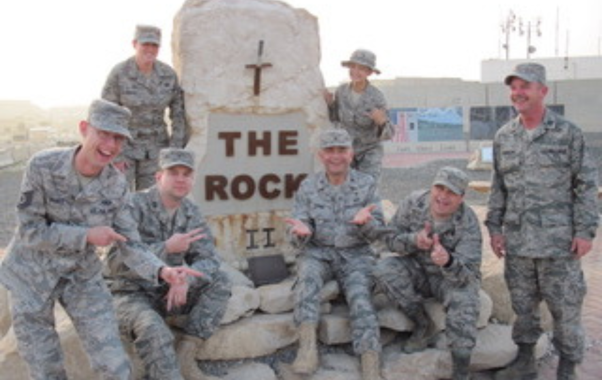 Br. Bob Bruno, OFM, seated to the right of the rock, with The Chaplain Corps Team (386th Air Base Wing, Kuwait). This version is not a formal pose, a testament to the team’s comfort level in his presence. (Photo courtesy of Br. Bob)