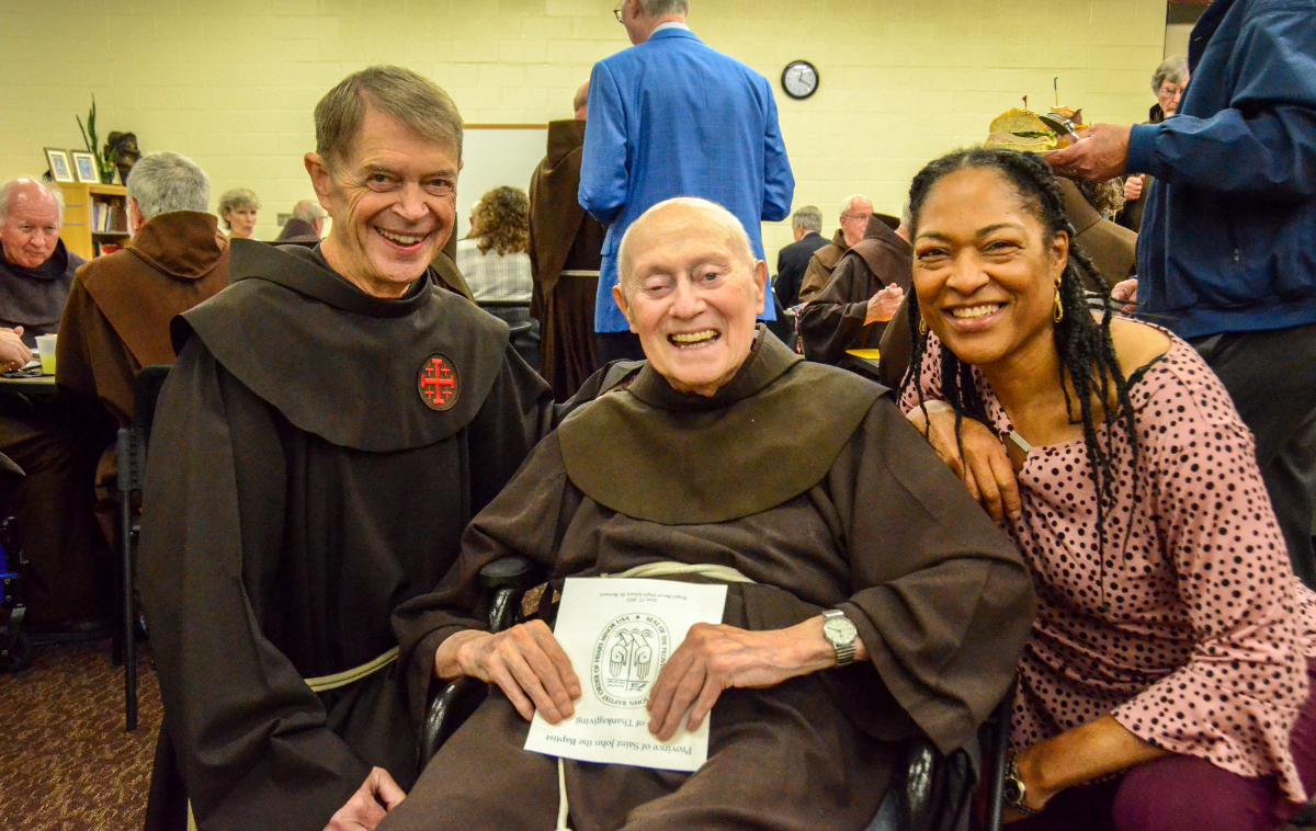 From left, Br. Maynard Tetreault, OFM, center, poses with Br. Larry Dunham, OFM, and Annie Timmons, Friars Club president, during a celebration. (Photo by Br. Frank Jasper, OFM)