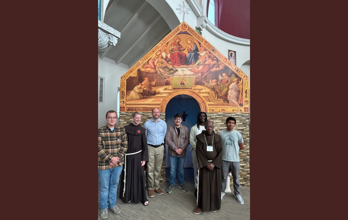 Discerners from the Cincinnati Come and See Weekend stand in front of the model of the Portiuncula, along with Brothers Larry Dunham, OFM, left, and Br. Robert Seay, OFM, the project’s creator. (Photo courtesy of Br. Greg Plata, OFM)