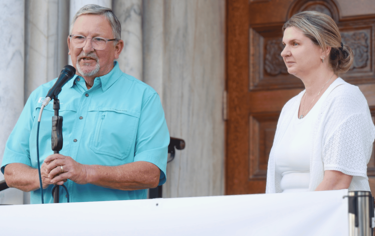 Tom Henry and Catholic Charities of the Diocese of St. Petersburg executive director Maggie Rogers address attendees at Bikes from the Heart's celebration of the 3,000th bike donated. "We have a wonderful community of volunteers. We encourage each other and are encouraged by each other," Tom said. (Photo courtesy of Sacred Heart Parish)