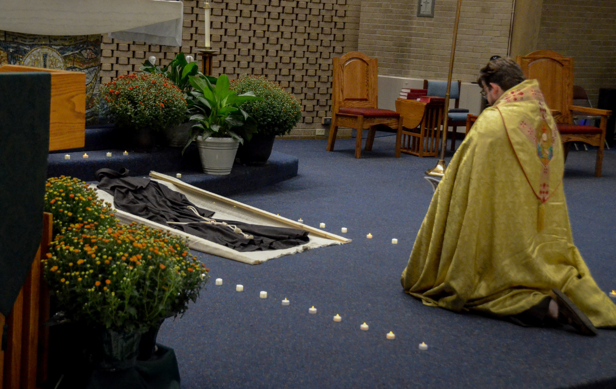 Br. Joshua Richter, OFM, kneels in prayer before a Franciscan habit placed at the altar during the Transitus. (Photo by Br. Frank Jasper, OFM)