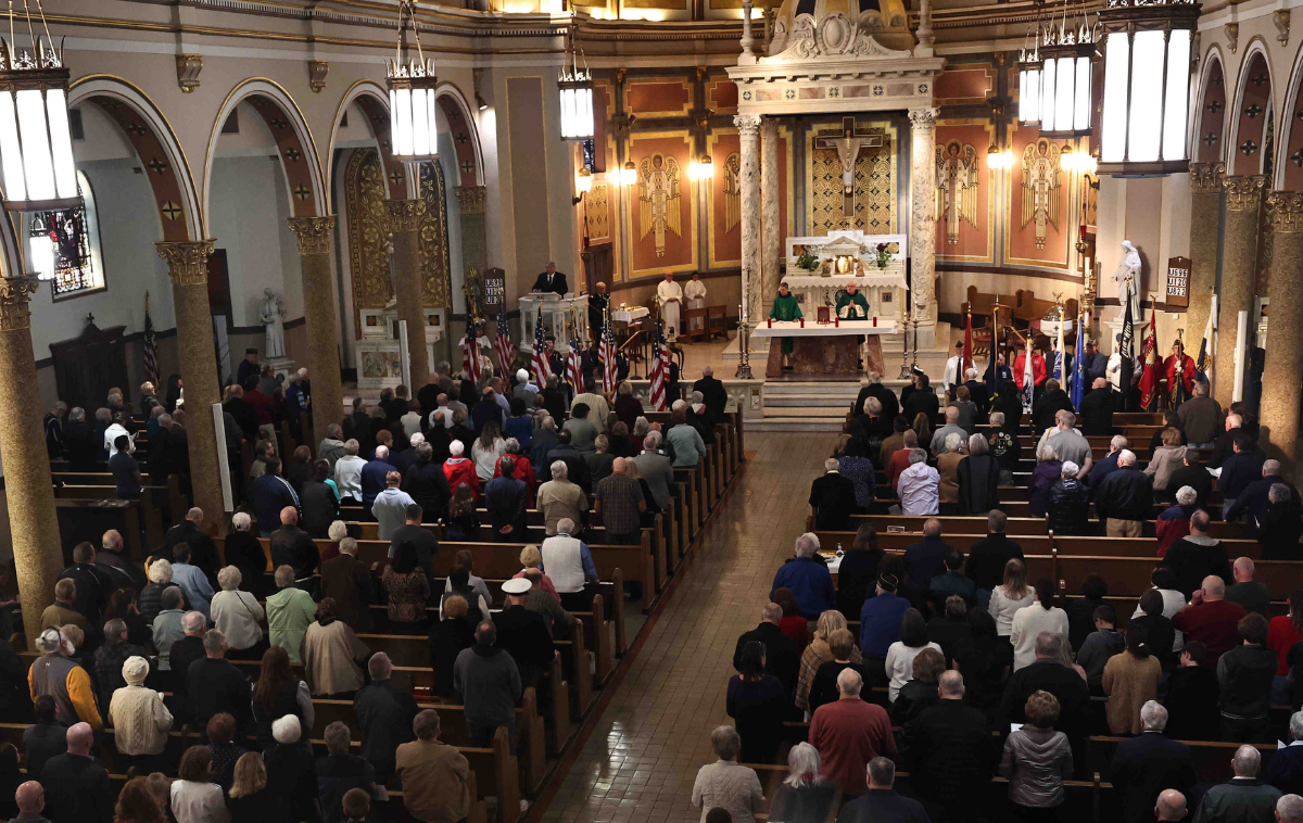 Veterans and their families sit in the pews of a large church