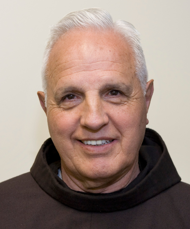 A smiling man in a friar habit.